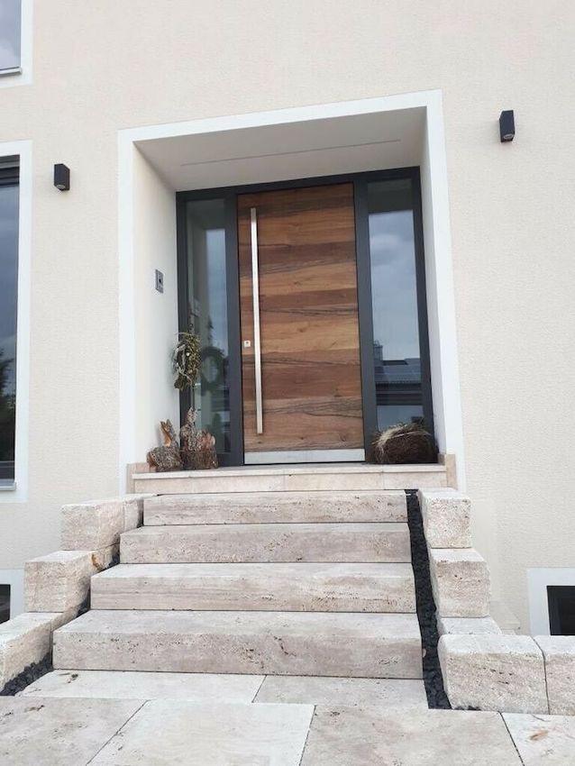 Blockstufen aus Travertin Classic Beige als Hauseingangstreppe vor einer Holztür mit seitlichen Glasflächen.