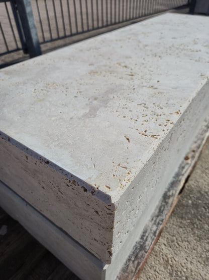 Blockstufe aus Travertin Classic Beige mit offenporiger Oberfläche und gefaster Vorderkante in Nahaufnahme.