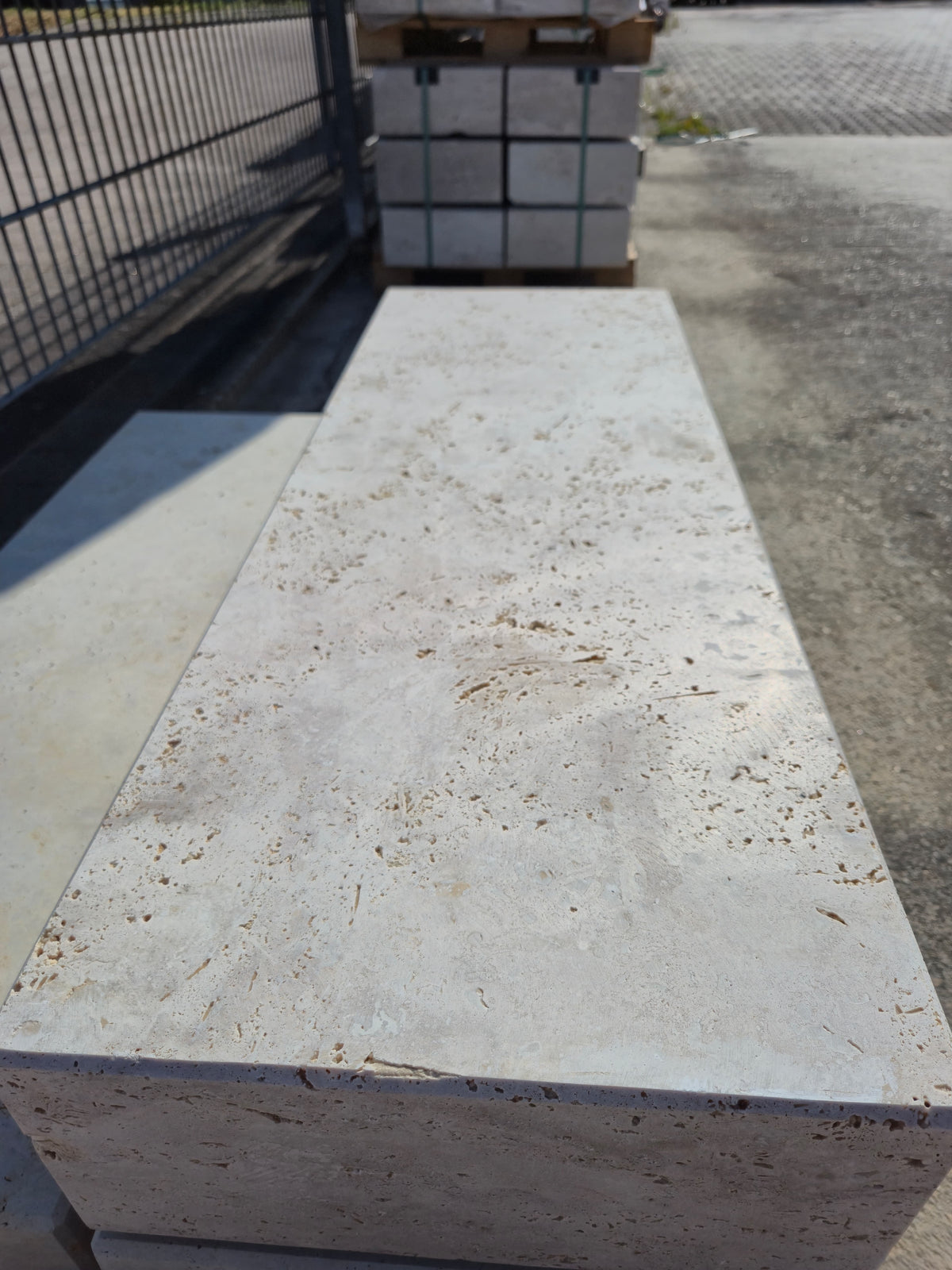 Oberseite einer Blockstufe aus Travertin Classic Beige mit natürlichen Poren und gefaster Kante.